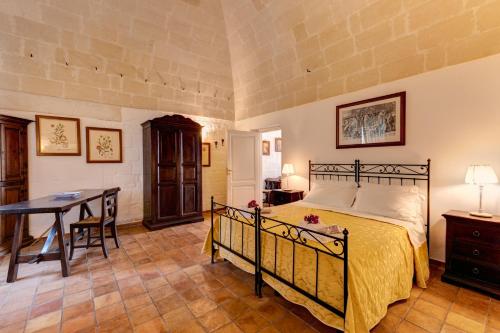 a bedroom with a bed and a table and a desk at Agriturismo La Stornara, Petfriendly & EV Friendly in Ginosa Marina