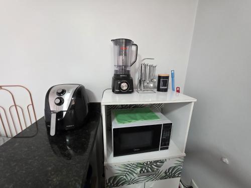 a counter with a blender on top of a microwave at Suíte1 Privativa Climatizada Mobiliada com Garagem e Wi-Fi in Goiânia