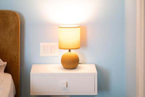 a lamp sitting on a night stand next to a bed at Aria Rooms in Procida