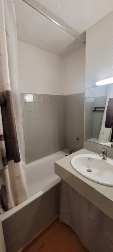 une salle de bain avec un lavabo et une baignoire et un lavabo dans l'établissement Studio Résidence Cap Soleil, à Saint-Mandrier-sur-Mer