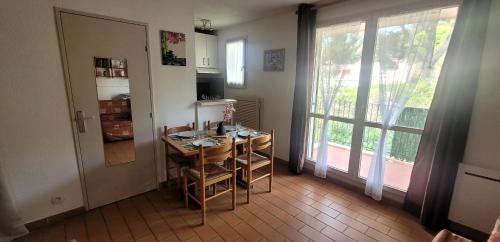 une cuisine avec une petite table et une porte avec une fenêtre dans l'établissement Studio Résidence Cap Soleil, à Saint-Mandrier-sur-Mer