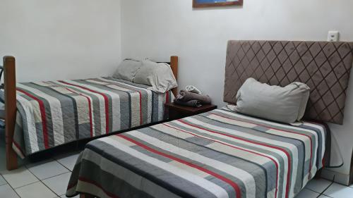 a bedroom with two beds with a striped blanket at Barato y tranquilo olas in Manzanillo