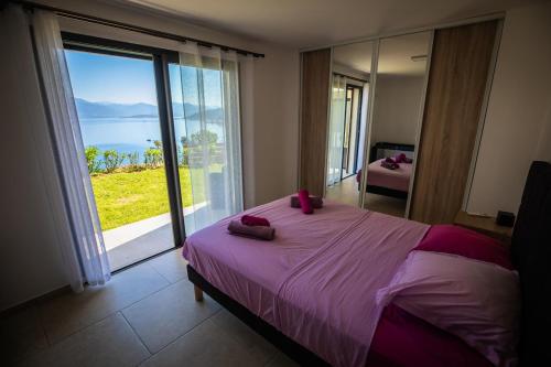 una camera da letto con un letto con vista sull'oceano di Villa d'architecte classée 5 étoiles a Campomoro
