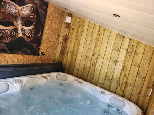 un jacuzzi dans une pièce avec un masque dans l'établissement LE SECRET LOVE ROOM, à Saint-Aigulin