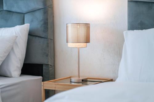 a lamp on a night stand next to a bed at Élégant appartement F3 au centre in Kenitra