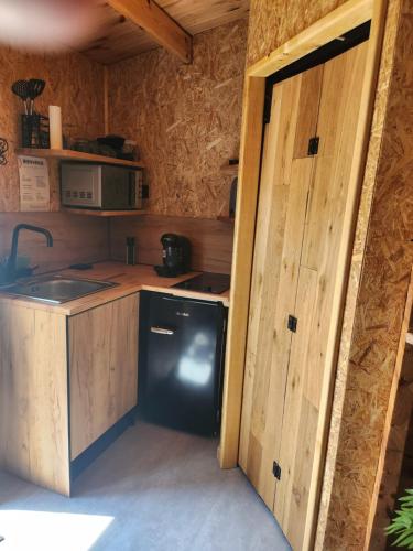 une petite cuisine avec un évier et un réfrigérateur dans l'établissement LE SECRET LOVE ROOM, à Saint-Aigulin