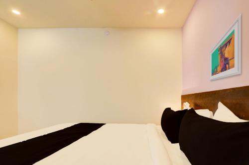 a bedroom with a bed and a painting on the wall at Hotel O S L N Grand in Upal