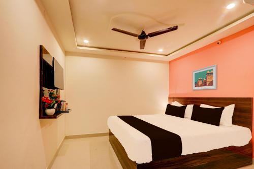 a bedroom with a bed and a ceiling fan at Hotel O S L N Grand in Upal