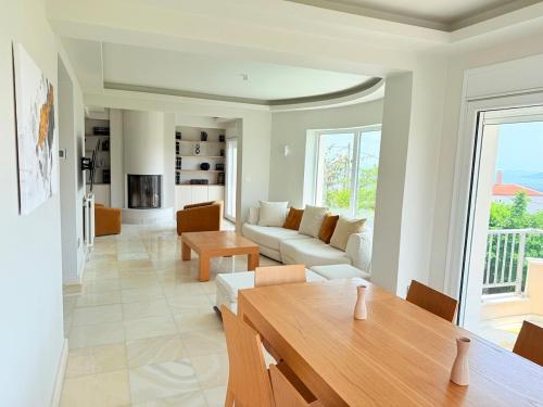 a living room with a couch and a table at Luxury SeaView Villa Pool-Bbq in Neos Voutzas