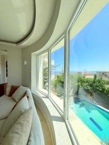 a living room with a couch and a swimming pool at Luxury SeaView Villa Pool-Bbq in Neos Voutzas