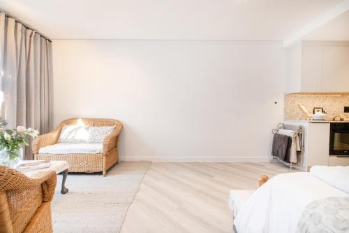 a white room with a chair and a couch at Olyfberg Rus in Paarl