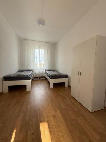 Habitación vacía con 2 camas y ventana en Apartment Borsdorf 2 R, en Leipzig