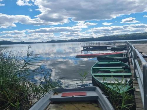 three boats are docked at a dock on a lake at Tranquil Lakefront holiday home in Lubrza