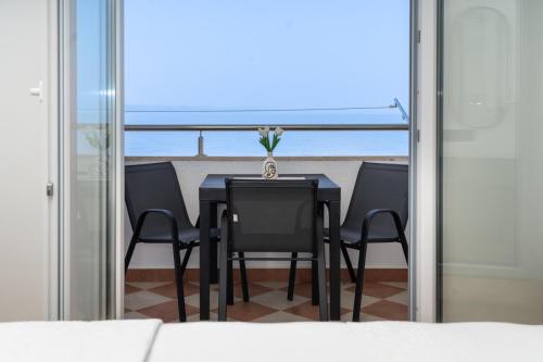 a dining room table with chairs and a view of the ocean at Apartmani Miranda in Drasnice