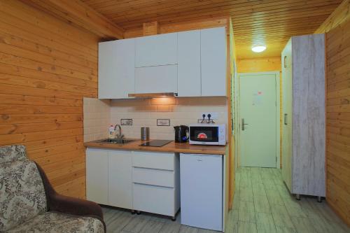 a kitchen with white cabinets and a counter with a microwave at New Gudauri Rooms in Gudauri
