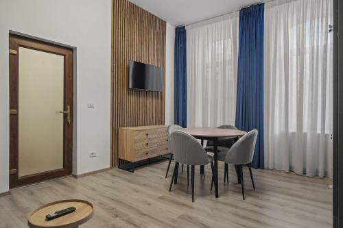 a dining room with a table and chairs and a television at Interbelic Villa close to Old Town in Bucharest