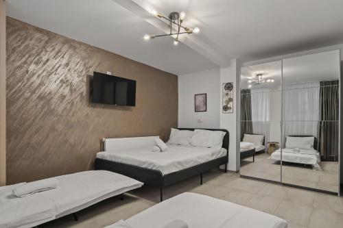 a bedroom with two beds and a tv on a wall at Interbelic Villa close to Old Town in Bucharest