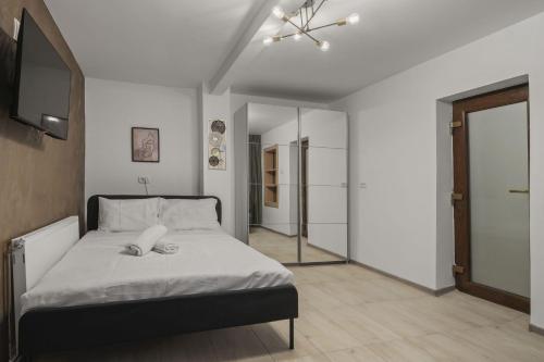 a bedroom with a bed and a television in it at Interbelic Villa close to Old Town in Bucharest