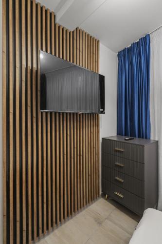 a bedroom with a dresser and a tv on a wall at Interbelic Villa close to Old Town in Bucharest
