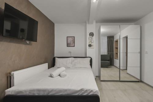 a bedroom with a bed with a flat screen tv at Interbelic Villa close to Old Town in Bucharest