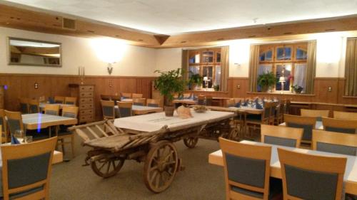 a room with tables and chairs and a wooden cart at Hotel Danis in Lenzerheide