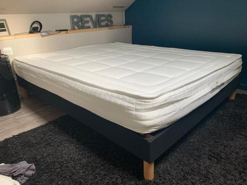 a bed in a room with a white mattress at Les lauriers du loft in Pazayac