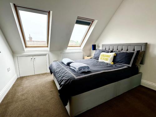 a bedroom with a large bed with two windows at Stunning Modern, Private Apartment,15 Mins To Central London in The Hyde