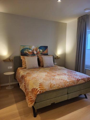 a bedroom with a large bed with a painting on the wall at B&B Ut Zuuje in Valkenburg