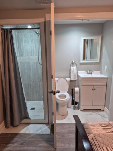 a bathroom with a toilet and a sink and a shower at Whitby one bedroom apartment in Whitby