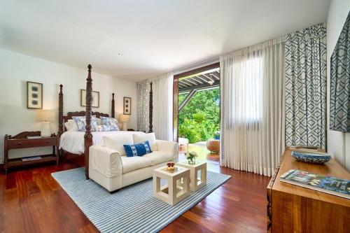 a bedroom with a bed and a couch and a table at Casa Adri in La Romana