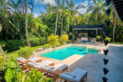 a swimming pool with chaise lounge chairs and a resort at Casa Adri in La Romana