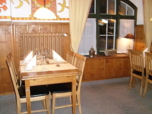 a dining room with a wooden table and chairs at Hotel Danis in Lenzerheide