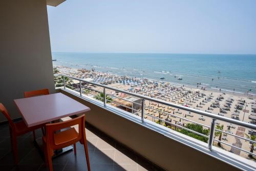 a balcony with a desk and a view of a beach at Rumar Hotel in Durrës