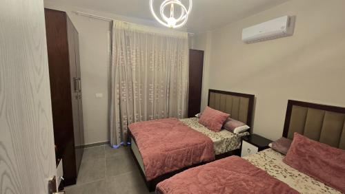a bedroom with two beds and a chandelier at boho elsokhna in Ain Sokhna