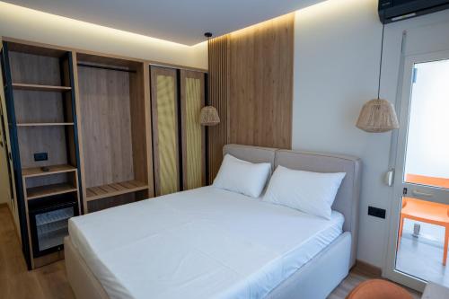 a bedroom with a white bed in a room at Rumar Hotel in Durrës