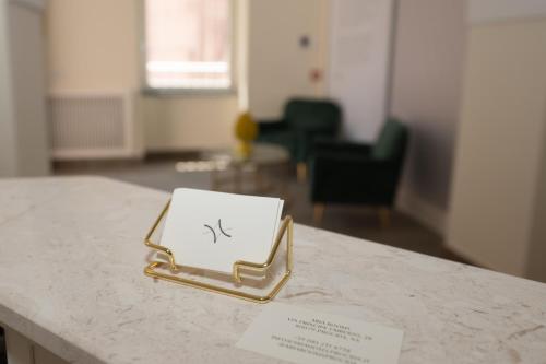 a gold tray on a counter with a paper on it at Aria Rooms in Procida
