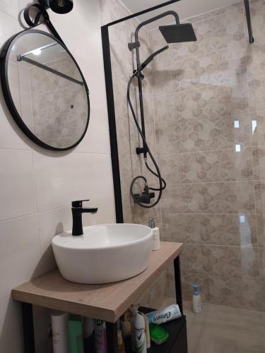 a bathroom with a white sink and a mirror at Sea & Silence Holiday House in Merdari
