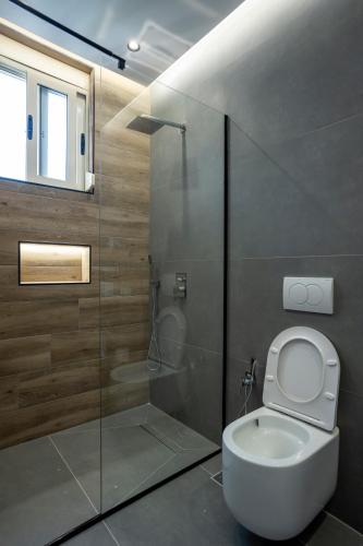 a bathroom with a toilet and a glass shower at Rumar Hotel in Durrës