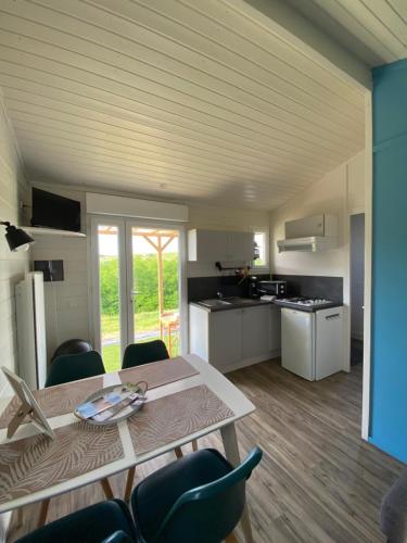 une cuisine et une salle à manger avec une table et des chaises dans l'établissement Cadoles du Domaine de Croifolie, à Salles-Arbuissonnas-en-Beaujolais