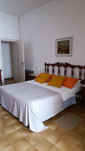 a bedroom with a large white bed with orange pillows at Casa di Silla in Torre del Lago Puccini
