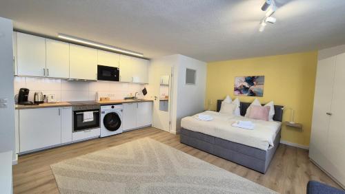 une petite chambre avec un lit et une cuisine dans l'établissement Nova Freiburg Dunantstraße, à Fribourg-en-Brisgau