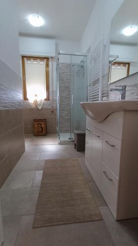 a bathroom with a sink and a glass shower at Casa di Silla in Torre del Lago Puccini