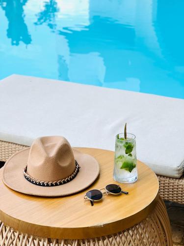 a hat and sunglasses on a table next to a pool at MYLOS Hotel Boutique in Guatapé
