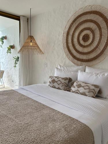 a bedroom with a large white bed with a chandelier at MYLOS Hotel Boutique in Guatapé
