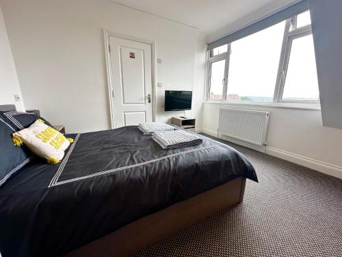 a bedroom with a large bed and a television at Stylish Modern, Private Apartment,15 Mins To Central London in Hendon