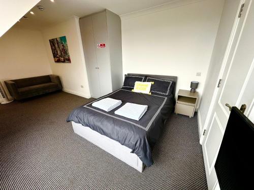 a bedroom with a bed and a chair in it at Stylish Modern, Private Apartment,15 Mins To Central London in Hendon