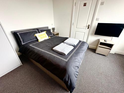 a bedroom with a bed with two keyboards and a television at Stylish Modern, Private Apartment,15 Mins To Central London in Hendon
