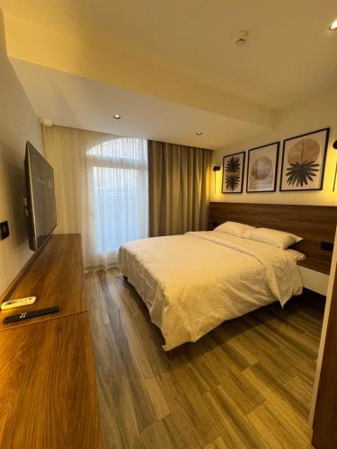 a bedroom with a bed and a flat screen tv at House 98 - Boutique Hotel Stay in Zayed in Sheikh Zayed