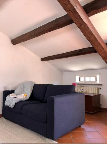 een blauwe bank in een woonkamer met houten plafonds bij Mansarda la Graziosa in Rimini
