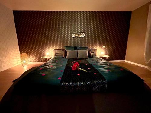 - une chambre avec un grand lit fleuri dans l'établissement Vénus - Maison de charme, zen avec SPA, à Plouray